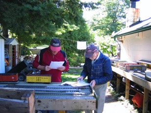 September 10.  It was our first opportunity to enjoy an operation session on Fred Mill’s Ironwood Peter’s Pond and Western Railroad. Here Gordy and Doug prepare the switchlists for the coming operation session.