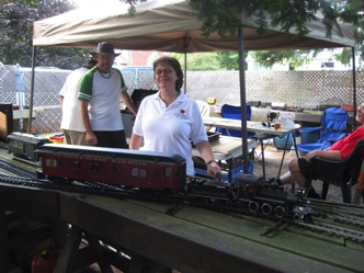 Jan Golding poses with her engine (the Bachmann Industrial Mogul) next to my parlor car in Craig Leigh.
