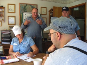 November 2. Sunday. The KVRY uses a dispatcher based in a room just off the kitchen. Train operators communicate via two-way radios to get permission to advance to the next town. Here, Jane Clarke, the dispatcher, checks a switch list while Bart looks on. In the background are Doug Matheson and Andy Clarke. November 2. Sunday. The KVRY uses a dispatcher based in a room just off the kitchen. Train operators communicate via two-way radios to get permission to advance to the next town. Here, Jane Clarke, the dispatcher, checks a switch list while Bart looks on. In the background are Doug Matheson and Andy Clarke.