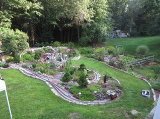 I usually take a picture of the layout from their deck, but by the time I remembered they had already set up some tents for shade, so I only got the right hand side of the layout. It's a good shot of Pearce in the lower right, with Majestic near the bridge left of center. It does not do justice so show off all of Martha's gorgeous flowers. Everywhere you look, there's just another great batch of them.