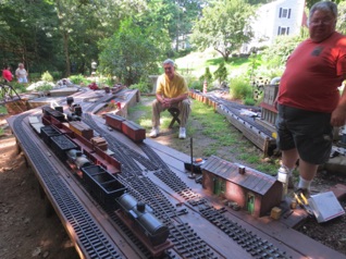 August 17. Saturday morning and it's time for operations!
The rolling stock is set out in the yards from the storage sheds, and then sweeper trains take the cars to the correct destinations. Paul looks to be supervising, while Jon awaits commands. August 17. Saturday morning and it's time for operations!
The rolling stock is set out in the yards from the storage sheds, and then sweeper trains take the cars to the correct destinations. Paul looks to be supervising, while Jon awaits commands.