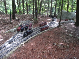 According to the flyer: Scale: Fn3 (1:20.3 3ft narrow gauge) Size: 200 ft x 180 ft, 12 scale miles of track Prototype: American 3 ft narrow gauge Local: rugged hills of the North East Era: 1940-1950s Style: linear with 4 main destinations yards, 8 branch lines, 10 major industries, and 14 additional switching locations Mainline run: 4 scale miles (1000 ft) Minimum degree of curve: 43° (2 Meters) Minimum Turnout: #6 for mainlines #4 for yards/Industries Maximum Grade: 2% mainline, 4% branch Elevation Change: 250 scale ft (13 feet) Roadbed: gravel roadbed Track: 110 lb rail (code 332 stainless steel and brass) According to the flyer: Scale: Fn3 (1:20.3 3ft narrow gauge) Size: 200 ft x 180 ft, 12 scale miles of track Prototype: American 3 ft narrow gauge Local: rugged hills of the North East Era: 1940-1950s Style: linear with 4 main destinations yards, 8 branch lines, 10 major industries, and 14 additional switching locations Mainline run: 4 scale miles (1000 ft) Minimum degree of curve: 43° (2 Meters) Minimum Turnout: #6 for mainlines #4 for yards/Industries Maximum Grade: 2% mainline, 4% branch Elevation Change: 250 scale ft (13 feet) Roadbed: gravel roadbed Track: 110 lb rail (code 332 stainless steel and brass)