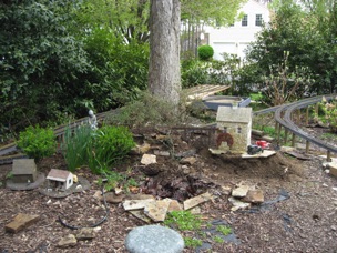 Although I built my stone mill a few years ago, it never had a proper spur. Even with my redesign, I couldn't get the track to curve enough to have a siding for the mill. Well, the rain was teasing me all morning, but I did manage to move the mill. It's not that I had to move it THAT far, but I did have to move the "mountain" that provided water for the pond. You can just make out a depression where the old pond used to be, just to the right of the daffodils.