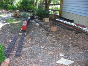 Well, on one of the nicest summer days in a long time, I managed to get some layout work done today. I put in the length of track that will eventually connect to the double siding in the foreground. Of course, it's a bit hard to see with the train on it. But, now it has me thinking. Would it be better to have an industry for each siding? Instead of two sidings for one industry? 