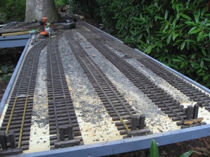 I was also able to extend the arrival departure track - last time, I had to cut my caboose off before I entered it. While the oak tree has been a constant problem with leaves, bark, twigs, and acorns falling on the track, today it really helped. It started raining while I was doing this, but it kept me dry. So, I was able to get all the track in place. It's a good thing I had saved a lot of my short sections. 