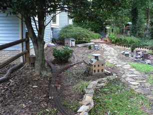 Work continues. I put in the passing siding in Jackson, so the town is basically complete. I removed a switch up by the hose cart, finally concluding that it would be too difficult to spot cars there under the tree. 