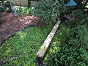 June 18.  The first step is to see how straight it is. I put a pressure treated 2 x 6 on top to see how long the viaduct should be.
I decided on 7' for the length of the viaduct; I'll have an arch cut every foot - so there will be 7 arches total, each half of a 10" diameter circle, with 2" pillars in between each arch.

I will use the 2x6 as a platform to lay the track on - just flex track in this case. I'm hoping I can find some AMS tie strips somewhere, so I can use the existing rails.

I am making the sides out of 3/8" Sintec (foamed PVC sheet). They will be 7" high, so I need to cut them to size first. The PVC is 24" x 48" long.