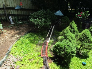 I use a pick to clear the area for the viaduct and put down some stone dust to help hold it in place and provide some drainage - just so the wood is never tempted to rot.

The track is just laid temporarily in place to see how it's going to look. The near through girder just has a coat of primer on it - I just finished the angle pieces on it yesterday.